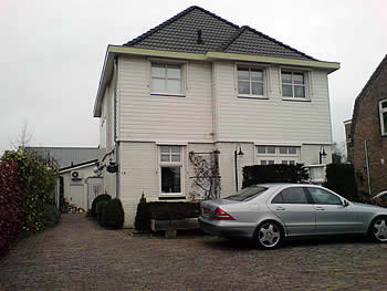 Het woonhuis aan de kant van de weg met daar achter de behandelruimte